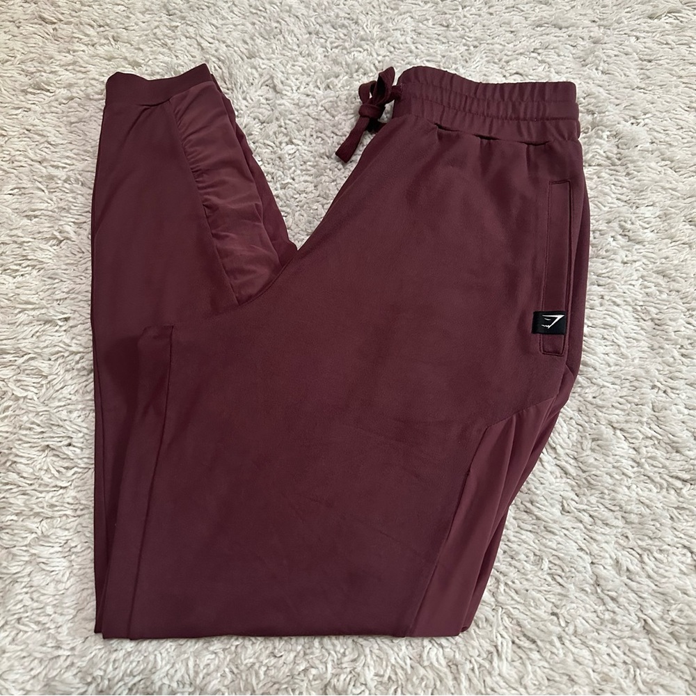 Gymshark burgundy joggers feature a minimalist branded tag side pocket sz small